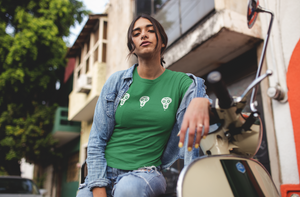Three white lazybones skulls on a go green t-shirt work by a good looking young lady sat on an old fashion scooter